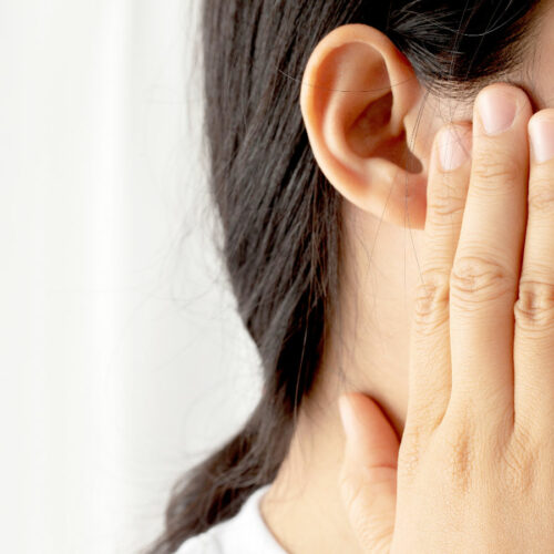 woman holding her ear suffering from tinnitus